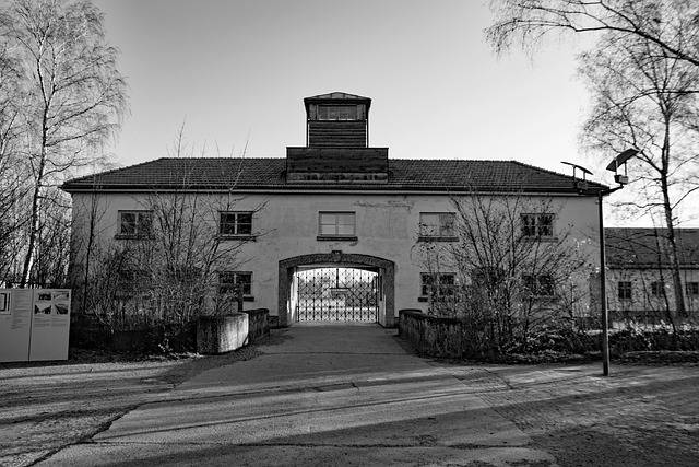 Während der Klassenfahrt nach München besucht die Schulklasse das KZ Dachau. Im Bild sehen wir das Eingangsportal des KZ in schwarz-weiß.